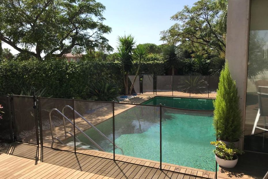 Piscina de una casa donde se puede apreciar las vallas de protección que hay para proteger la piscina